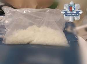 Zabezpieczone narkotyki, w prawym górnym rogu znajduje się logo Komendy Powiatowej Policji w Pabianicach.