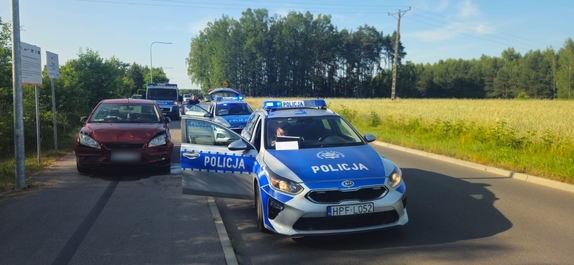 Auto zatrzymanego mężczyzny obok policyjnego radiowozu.