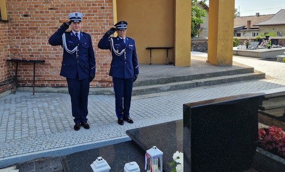 Policjanci oddają hołd przed grobem zmarłego funkcjonariusza.