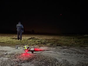 Policjant i dron z kamerą termowizyjną.