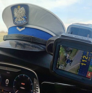 Ręczny miernik prędkości, a obok niego policyjna czapka.