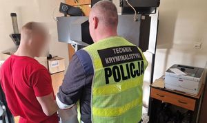 Technik kryminalistyki stoi z zatrzymanym mężczyzną.