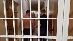 Policjant stoi z zatrzymanym mężczyzną