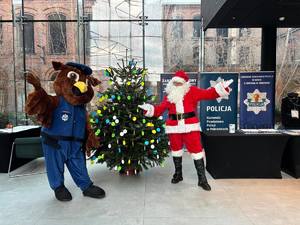 Mikołaj i maskotka pabianickiej Policji przy odblaskowej choince.