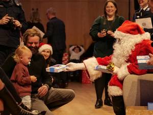 Dziecko odbiera czekoladki od Świętego Mikołaja.