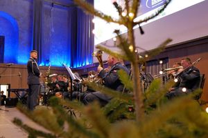 Za fragmentem choinki widać orkiestrę grającą na scenie.