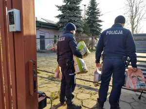 Policjanci wnoszą karmę na teren schroniska.