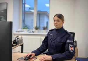 Policjantka siedząca przy biurku.