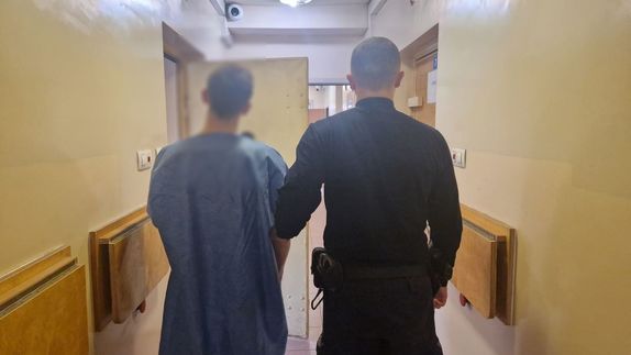 Policjant z zatrzymanym mężczyzną.