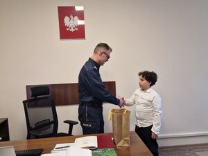 Komendant Powiatowy Policji w Pabianicach podaje rękę chłopcu.
