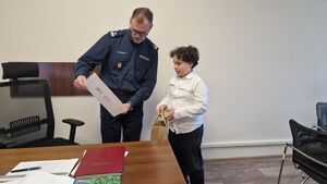 Komendant Powiatowy Policji w Pabianicach wręcza chłopcu list gratulacyjny.