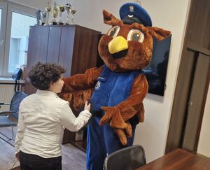 Chłopiec wita się z maskotką pabianickiej komendy Policji.