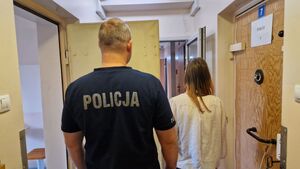 Policjant stoi z zatrzymaną kobietą.