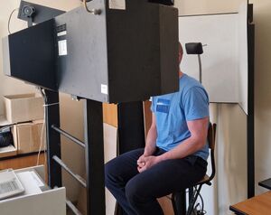 Zatrzymany mężczyzna siedzi na urządzeniu służącym do wykonywania zdjęć.