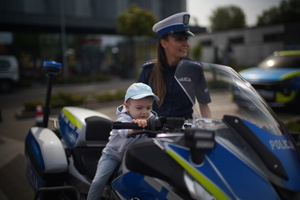 policjantka przy dziecku które siedzi na motorze