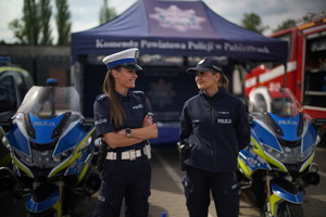 dwie policjantki stoją na tle namiotu Komendy Powiatowej w Pabianicach
