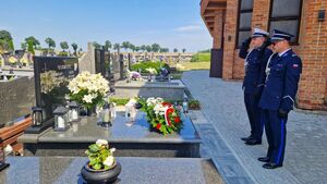Komendant Powiatowy Policji w Pabianicach, obok niego znajduje się Naczelnik Wydziału Ruchu Drogowego Komendy Powiatowej Policji w Pabianicach. Obaj stoją przed grobem zmarłego policjanta.