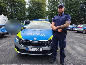 umundurowany policjant stojący przy radiowozie