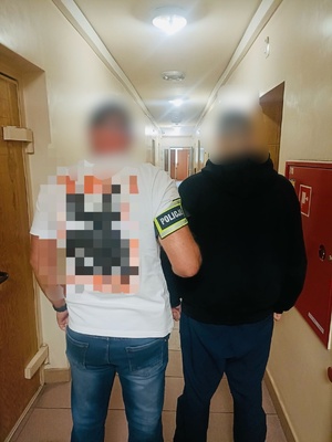 policjant z zatrzymanym mężczyzną