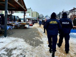 Policjant i strażnik miejski patrolują targowisko