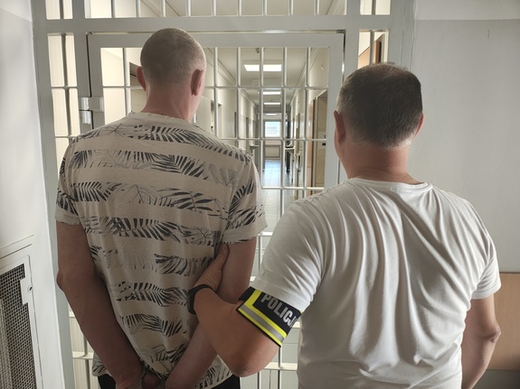 Policjant z zatrzymanym przed policyjna celą