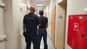 Policjant prowadzi zatrzymanego