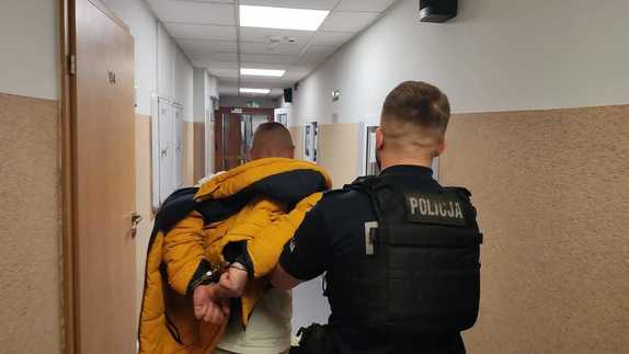 Policjant prowadzi zatrzymanego