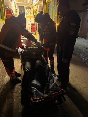 Policjanci wraz z ratownikami medycznymi udzielają pomocy wychłodzonemu mężczyźnie