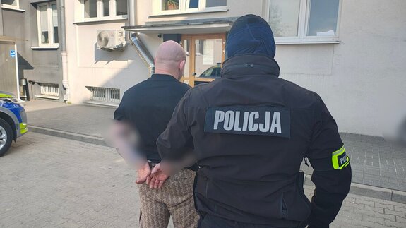 Policjant z zatrzymanym mężczyzną