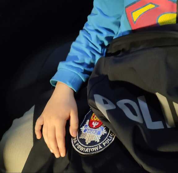 Chłopiec okryty policyjną kurtką