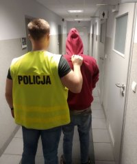 Policjant prowadzi zatrzymanego