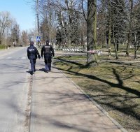 patrol mundurowy idzie chodnikiem na ulicy Koluszek