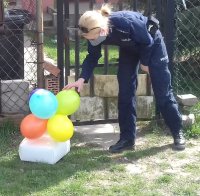 Policjanci dostarczają tort urodzinowy dla dziewczynki przebywającej na kwarantannie.
