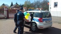 Policjanci dostarczają tort urodzinowy dla dziewczynki przebywającej na kwarantannie.