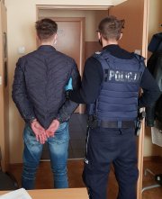 policjant prowadzi zatrzymanego