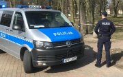 policjant stoi przy radiowozie