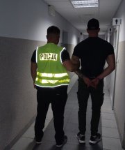 policjant prowadzi zatrzymanego