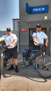 Policjanci stoją przy rowerach.