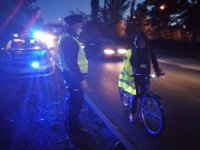 Dzielnicowy rozdaje kamizelki odblaskowe mieszkańcom.