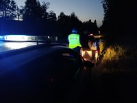Dzielnicowy rozdaje kamizelki odblaskowe mieszkańcom.