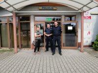 Policjanci stoją przed komisariatem z dziennikarką i pozują do zdjęcia.
