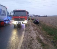 Samochody leżą w przydrożnym rowie, w pobliżu na drodze stoi radiowóz policyjny i wóz strażacki