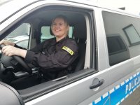 Umundurowana policjantka siedzi za kierownicą w radiowozie