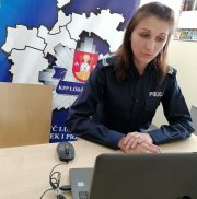 umundurowana policjantka siedzi przed komputerem