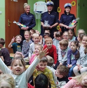 dzieci w grupie są przy stojących obok nich policjantach i pozują do zdjęcia