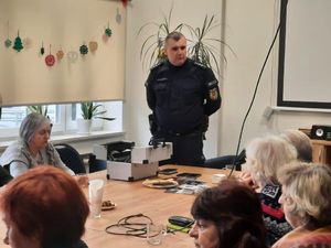 Policjant rozmawia na spotkaniu z seniorami