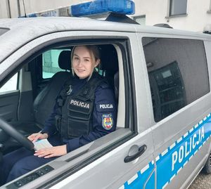 Policjantka przy radiowozie policyjnym.