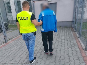 Policjant prowadzi zatrzymanego