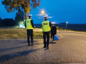 Policjanci podchodzą do kobiety.