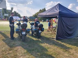 Trzech policjantów stoi przy motocyklach.